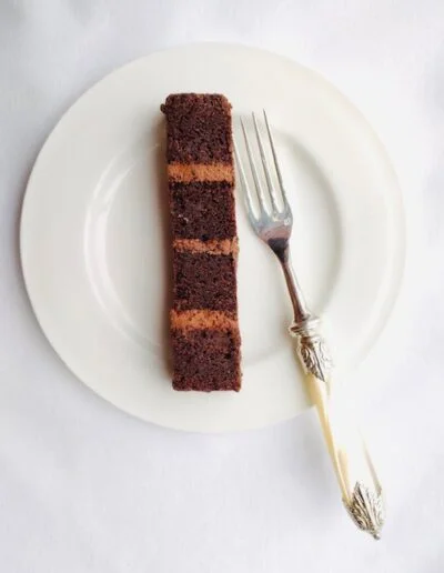 slice of chocolate cake with 4 layers and buttercream