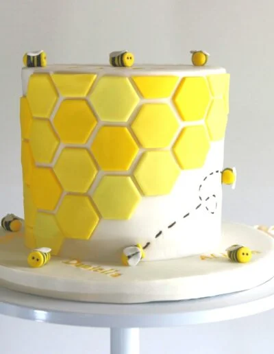 single tier cake with bees and hexagons